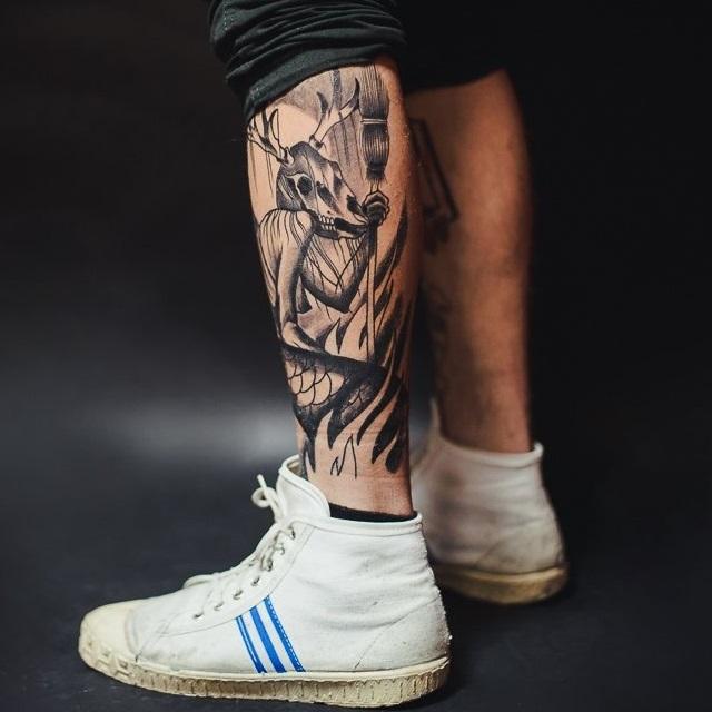 Black and white male tattoo on legs