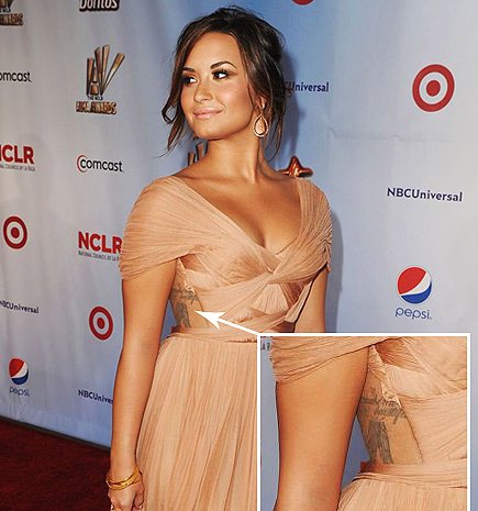 Lovato demo with tattoos on side of torso