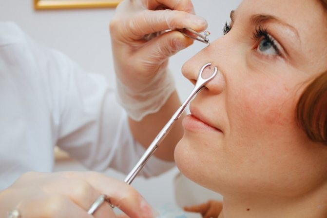 Doctor inserts earring into nose