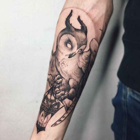 Lantern and owl tattoo on the forearm
