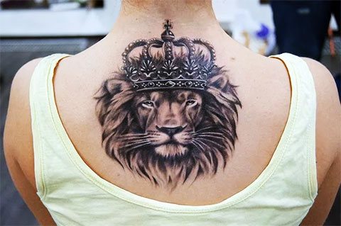 Tatuaż przedstawiający lwa z koroną na plecach dziewczyny