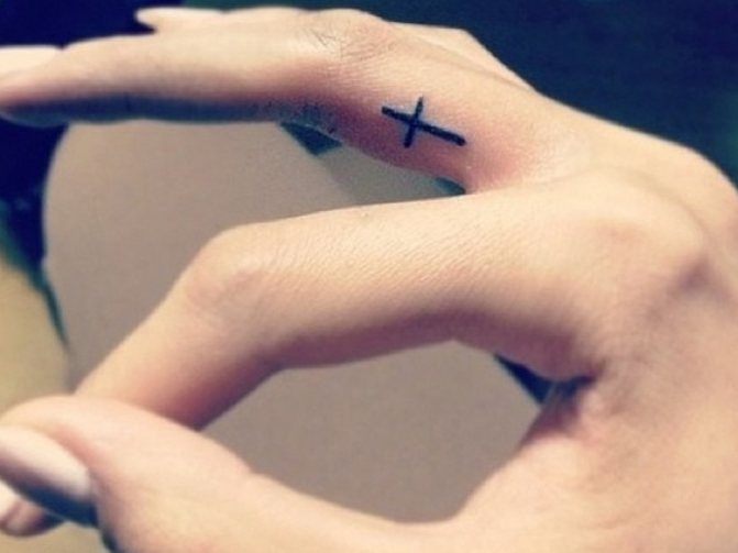 Cross tattoo on the finger - a hallmark of thieves
