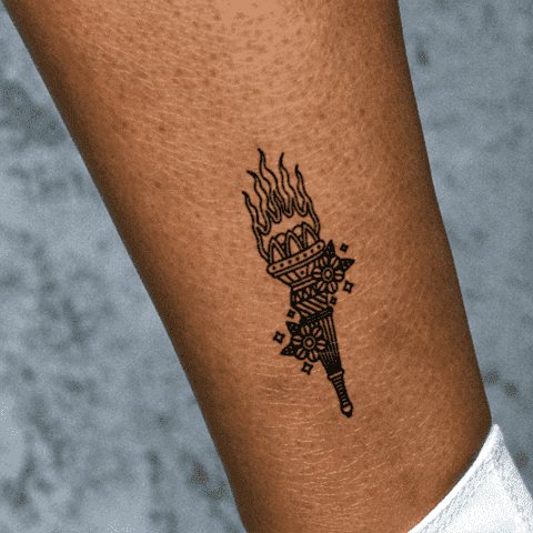 Small tattoo of a torch on the ankle