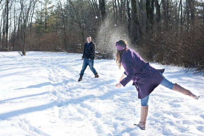 Man and woman playing snowballs