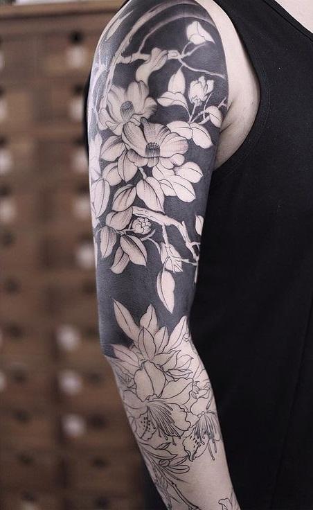 Man's tattoo on hand with elements of Blackwork and flowers