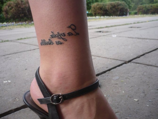 Ankle tattoo with a slogan