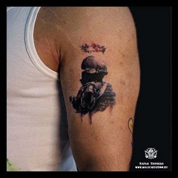 Small tattoo of a stalker on a guy's shoulder