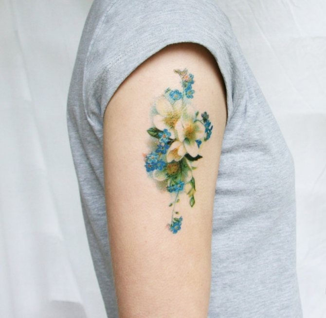 Delicate tattoo in the form of wildflowers on the shoulder