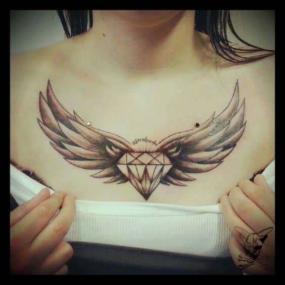 Tattoo of a diamond and wings above the chest