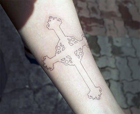 Tattoo black cross on left arm