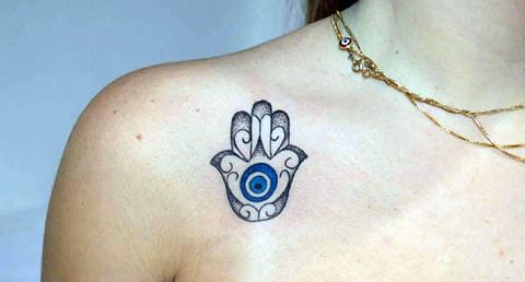 Tattoo of a sheep on a girl's collarbone