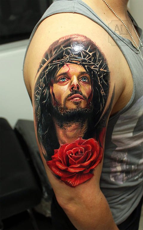 Tattoo of Jesus Christ with a crown of thorns and a rose on his arm