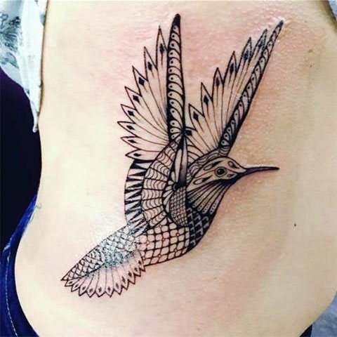 Tattoo of a hummingbird on the girl's side