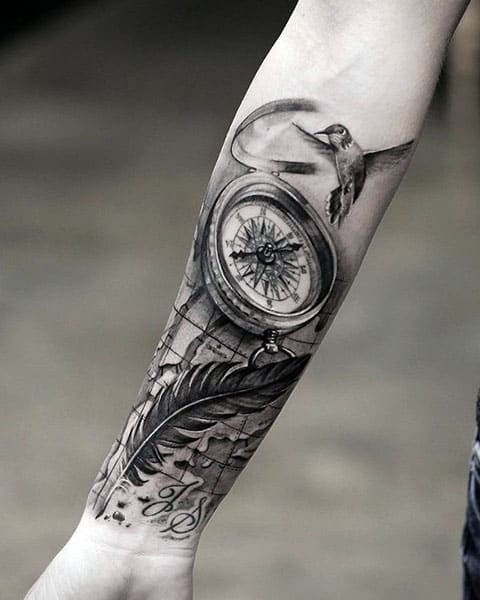 Tattoo compass and bird with feather on hand
