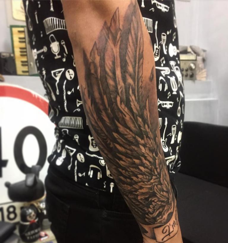 Le ali del tatuaggio si adattano perfettamente all'avambraccio maschile