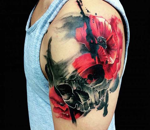 Tattoo of a poppy and skull on a man's shoulder