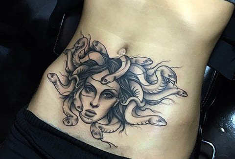 Tattoo of Medusa Gorgon on girls stomach