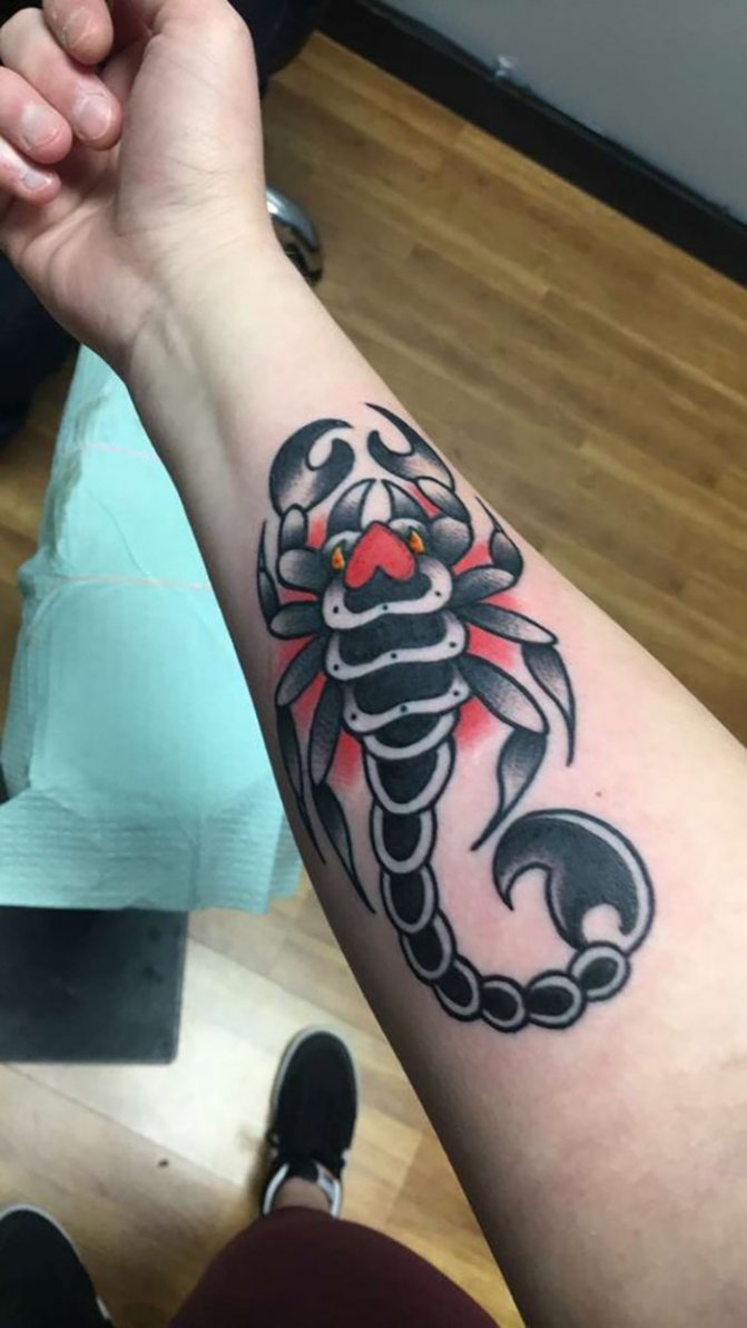 Forearm tattoo of a scorpion with a red circle