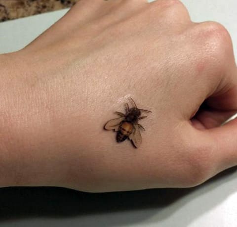 Tattoo of a bee on the hand