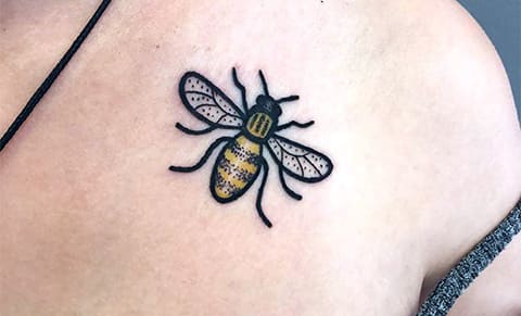 Tattoo bee on collarbone