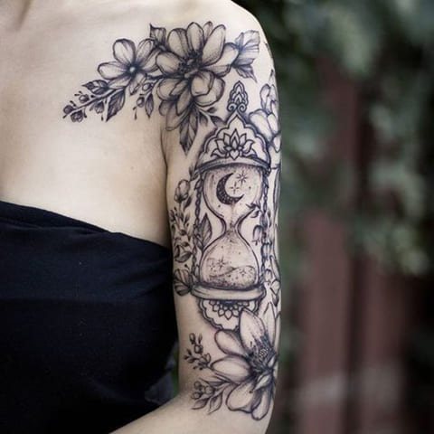 Hourglass and flowers tattoo on a girl's arm