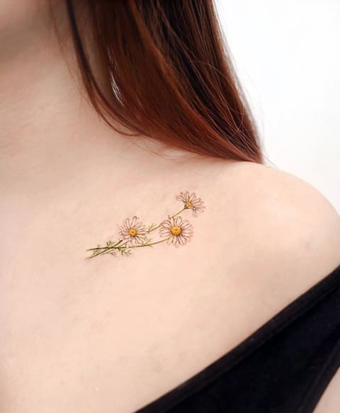 Tattoo of daisy on a girl's collarbone
