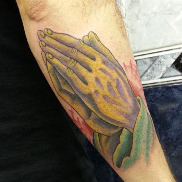 Tattoo of the praying hand on the forearm