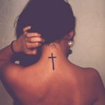 Tattoo of a cross on his back photo