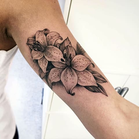 Tattoo with a lily on his arm