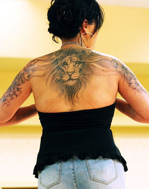 Tattoo of a lion on a girl's back