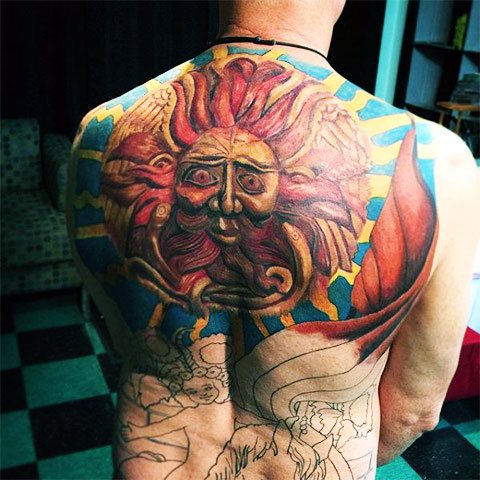 Tattoo of the sun on his back - photo