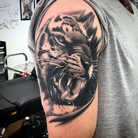 Tattoo of a tiger on his shoulder