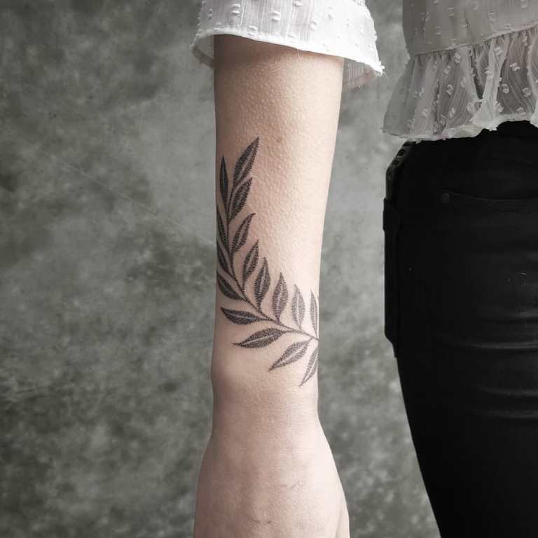 tattoo of a sprig on his arm