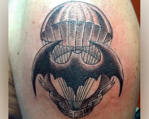 Military reconnaissance bat and parachute tattoo on his shoulder