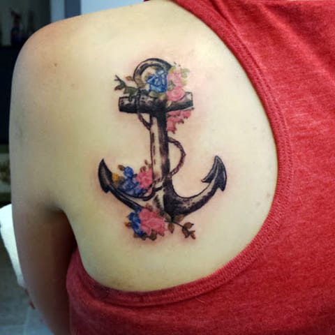 Tattoo anchor with flowers on girl's arm blade