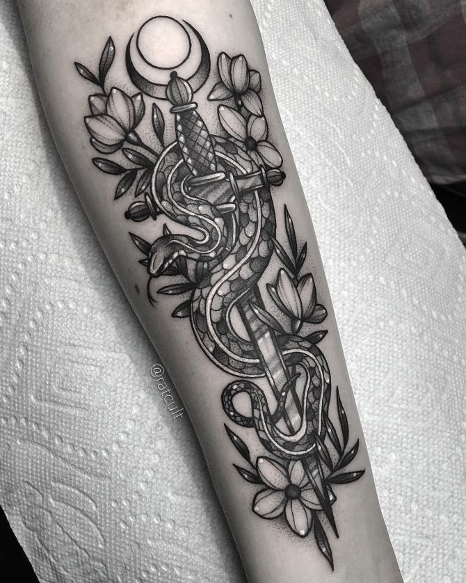 Tatuaggio con pugnale e serpente sul braccio della donna