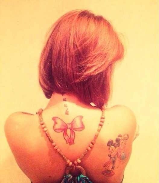 Tattoo bow on the back of Aiza Dolmatova
