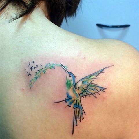 Tattoo of a hummingbird on a girl's shoulder blade
