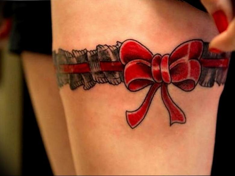 Red bow tattoo made in the shape of a garter