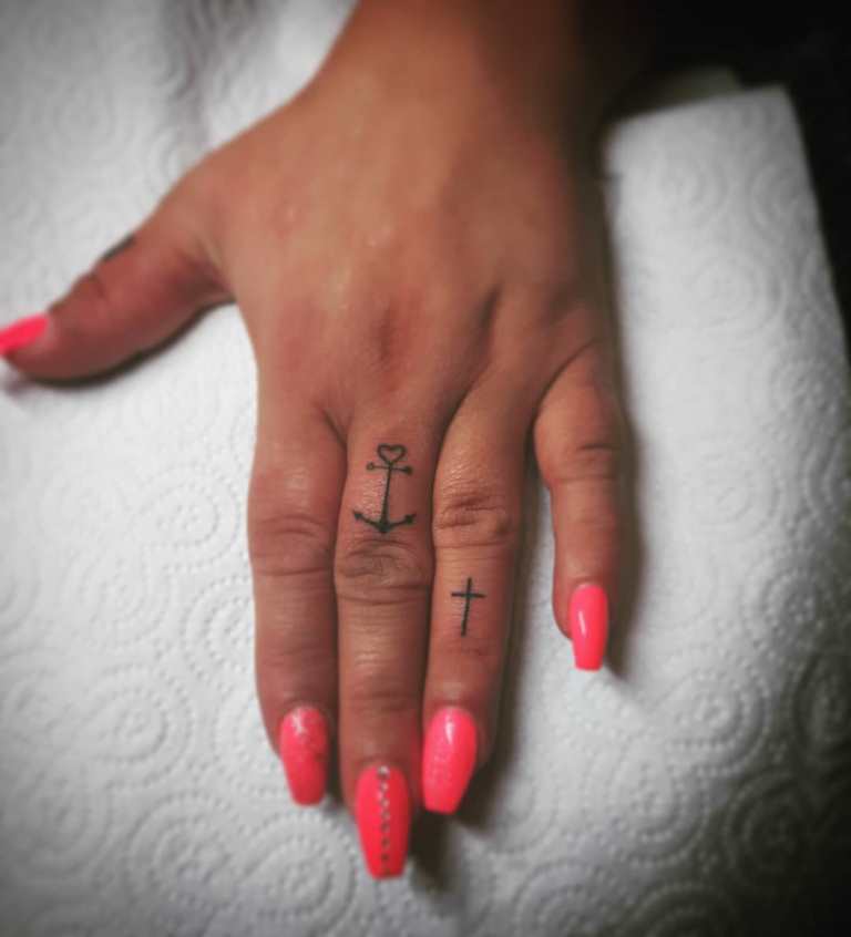 Tattoo of a cross on his finger