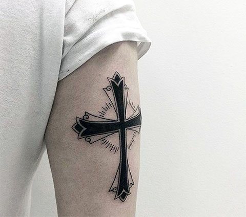 Tattoo of a cross on his arm