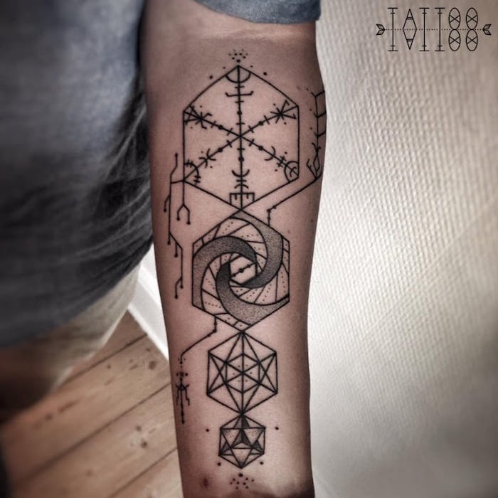 Tattoo mandala with runes on his arm