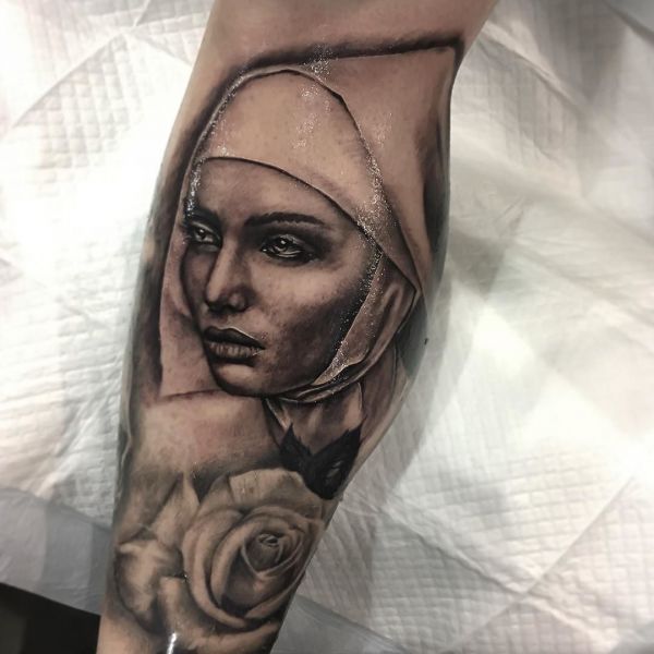 Tattoo of a nun with a rose on his armcrack