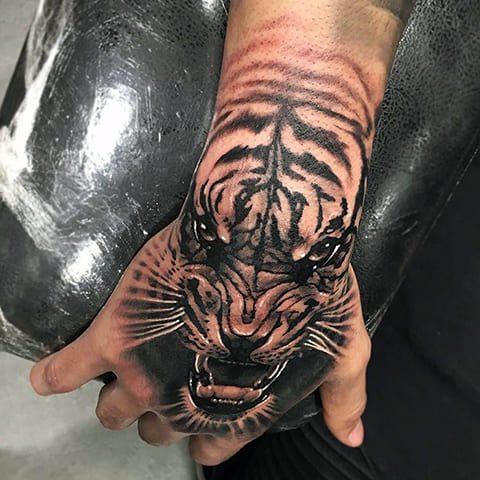 Tattoo of a tiger grinning on his arm