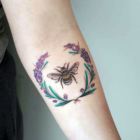 Tattoo of a bee and wreath
