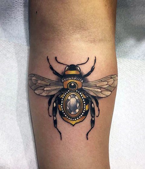 Tattoo of a bee on his arm