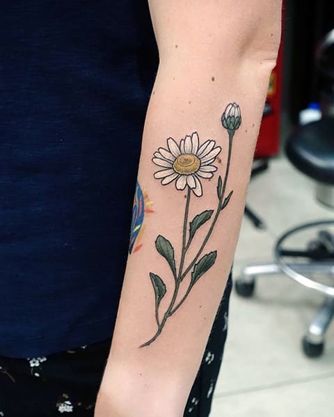 Tattoo of a daisy on the arm