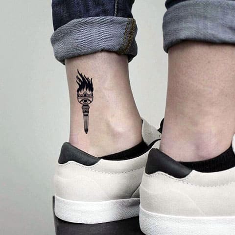 Tattoo with a small torch on his leg