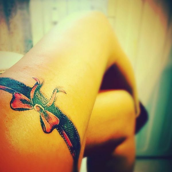 Tattoo of a girl as a garter on her leg