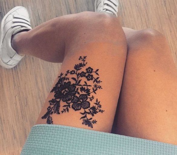 Tatuaggio in pizzo con turbinii sulla gamba di una ragazza